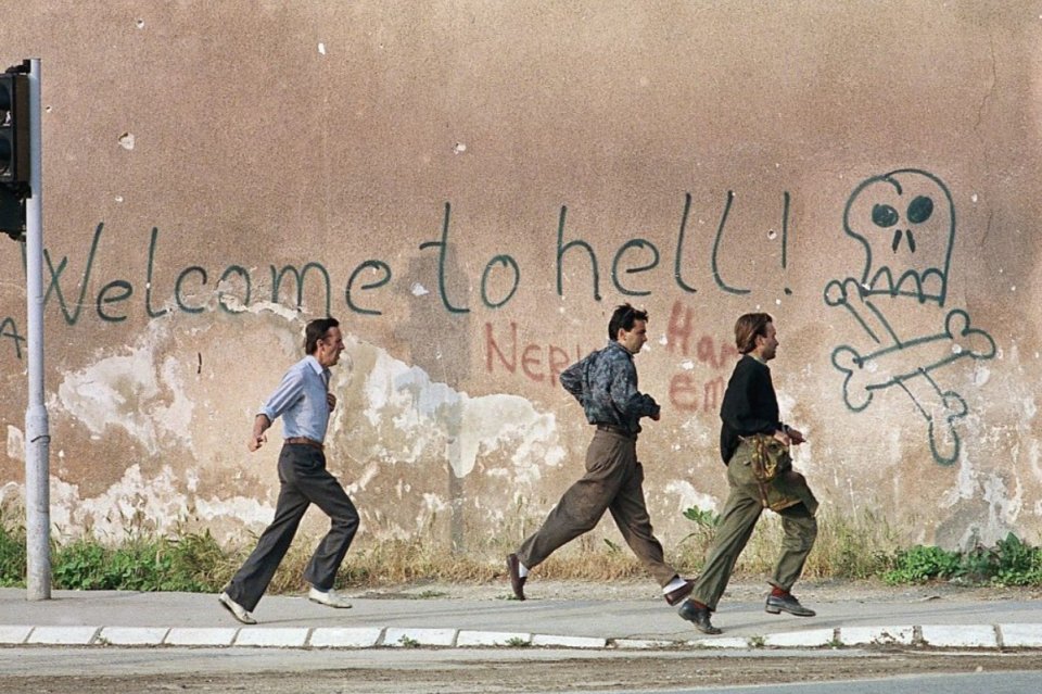 Cetățeni ai Sarajevoului care fug pe străzi, în timpul asediului