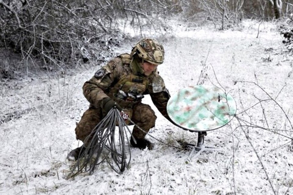Soldat ucrainean instalând echipament satelit Starlink
