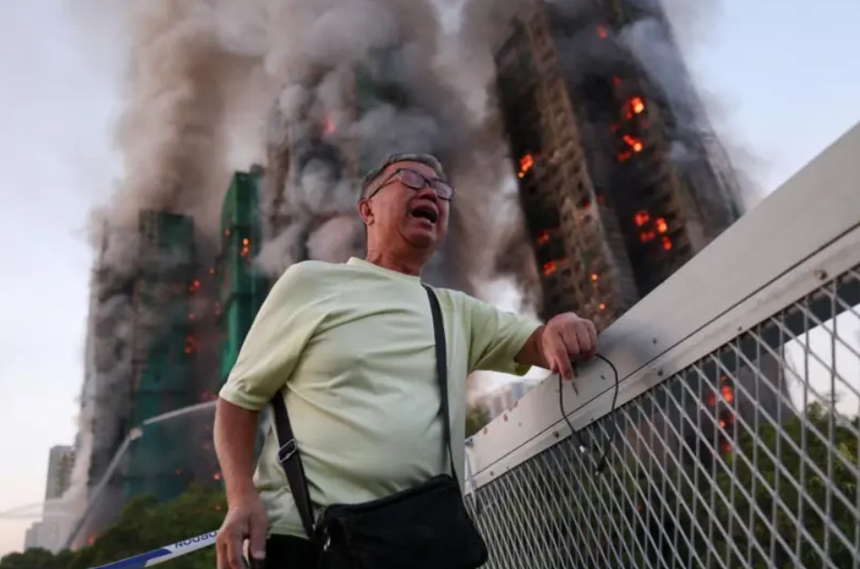 Localnic al Hong Kong-ului, în fața complexului care este mistuit de flăcări